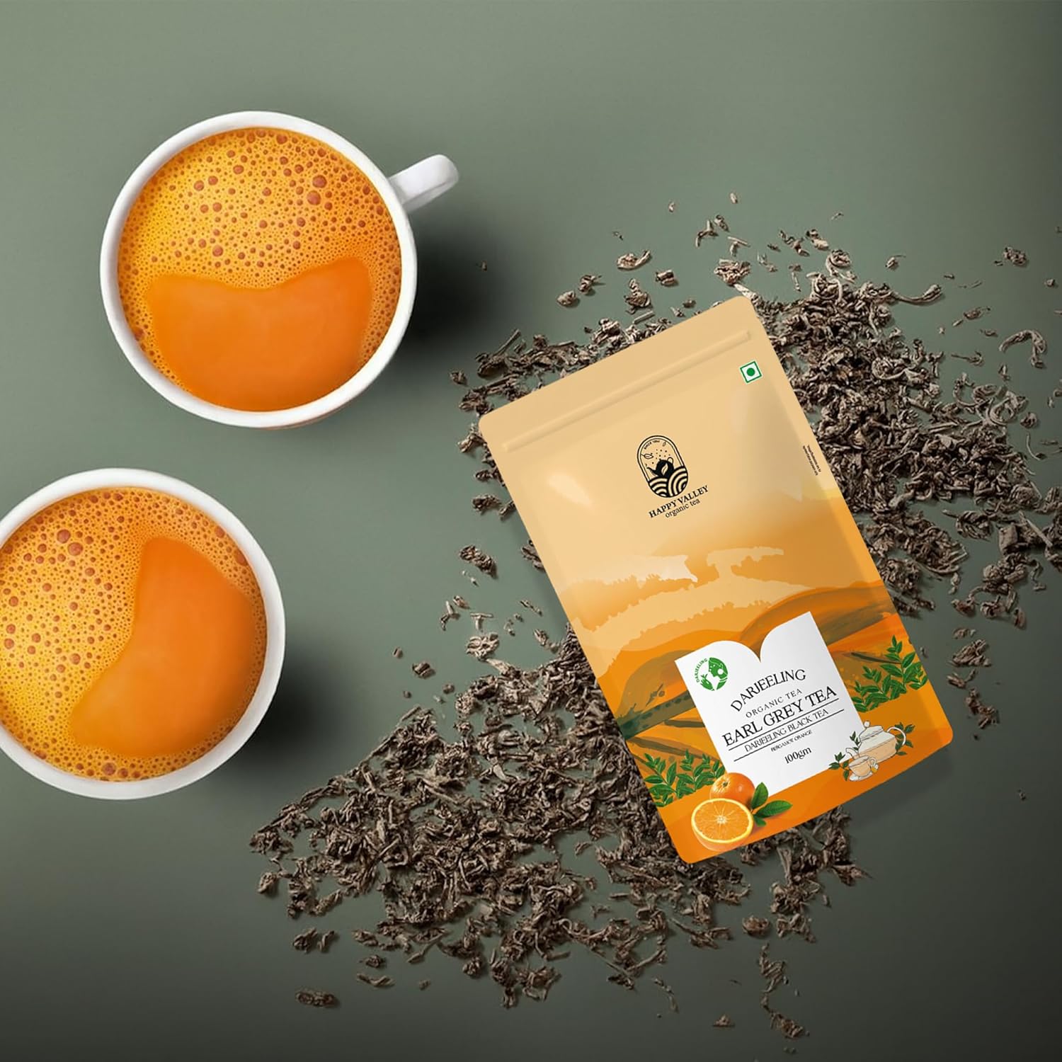 Earl Grey orange tea pouch styled with loose leaves and brewed cups