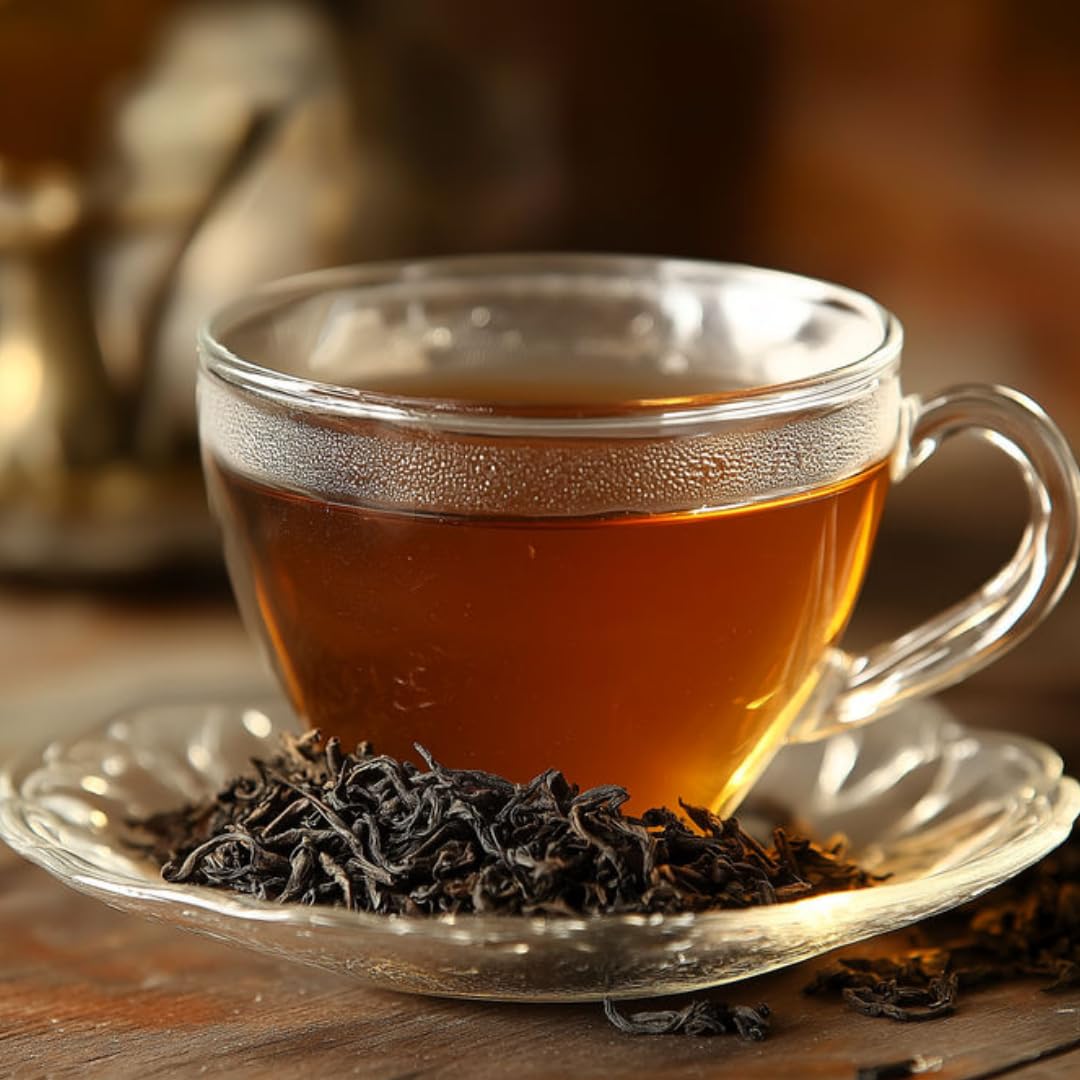 Glass cup of Darjeeling Earl Grey orange tea with aromatic black tea leaves